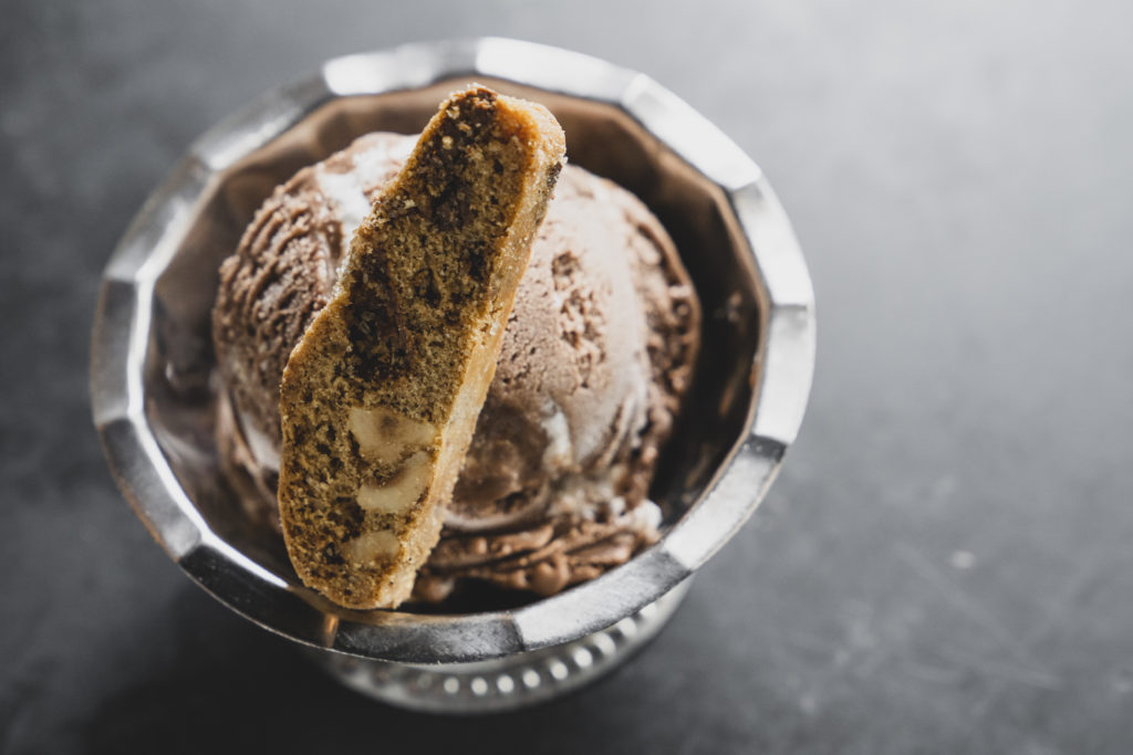 A scoop of gelato with a biscotti